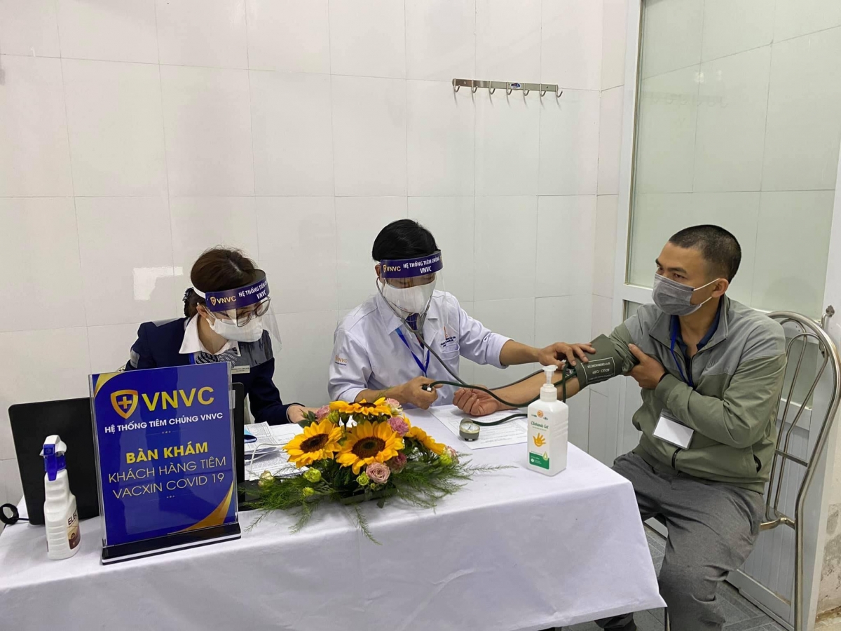 Người dân được kiểm tra sức khỏe trước khi tiêm vaccine Covid-19