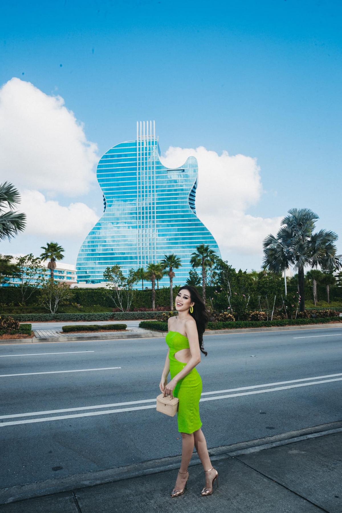 Người đẹp thường xuyên chọn các trang phục bó sát khoe trọn vóc dáng. Trong hình là chiếc váy của Nhà một 9192, lấy cảm hứng từ những đồi núi xanh ngát vùng cao nguyên Việt Nam và những đường uốn lượn bồng bềnh của mây núi. Trên tay cô cầm chiếc túi đan bằng sợi chiếu cói, sản phẩm thủ công mỹ nghệ của làng nghề Việt Nam.
 