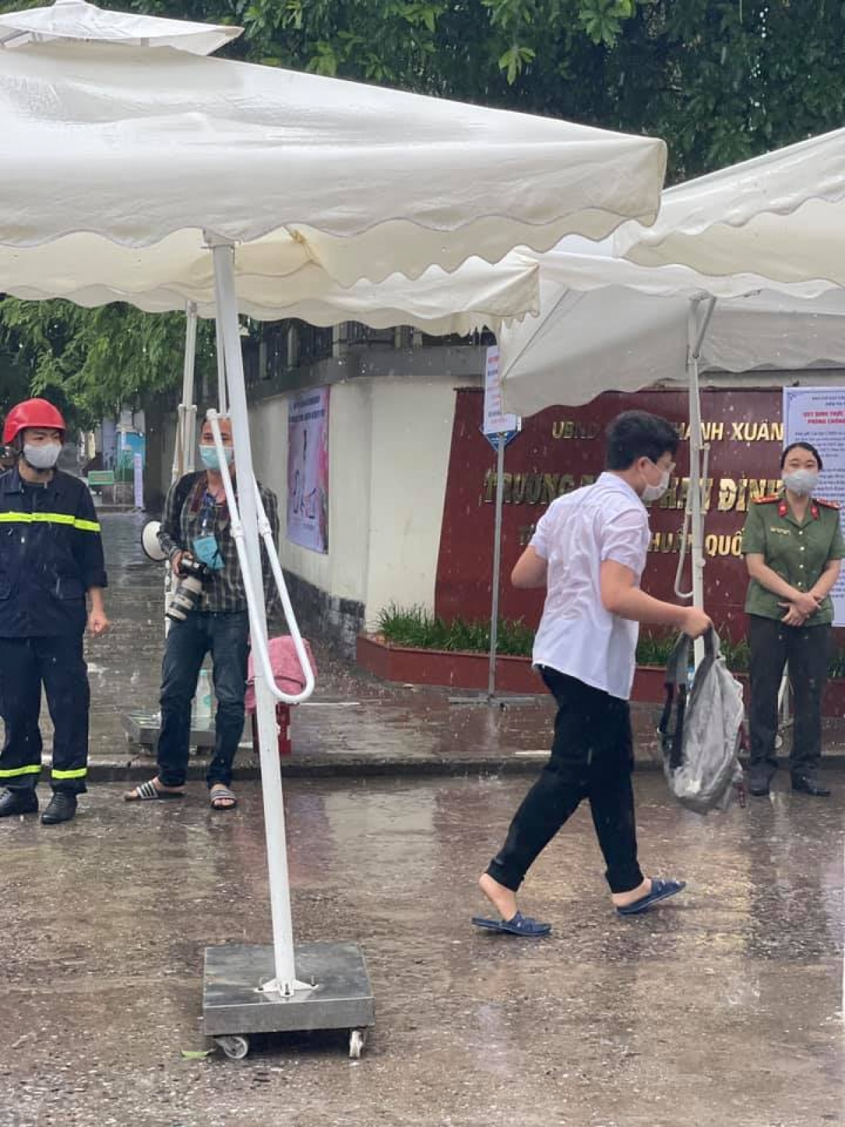 Thí sinh đội mưa đến điểm thi Trường THPT Phan Đình Giót