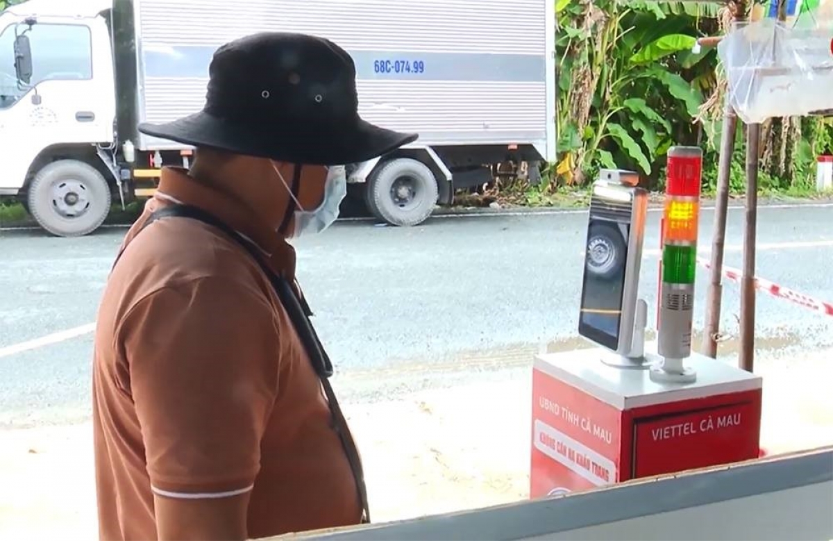 Người dân đứng trước máy quét để nhận diện khuôn mặt, thực hiện khai báo y tế