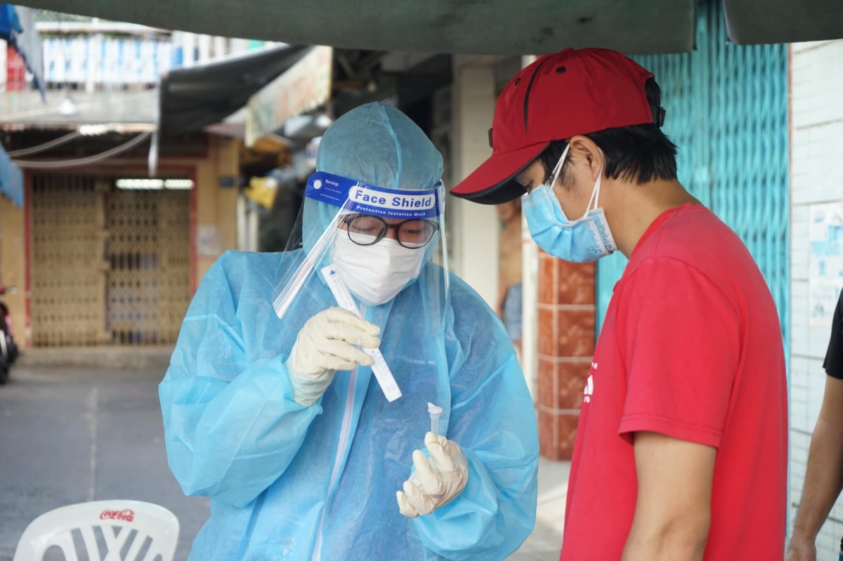 Nhân viên y tế hướng dẫn người dân tự làm test nhanh tại nhà