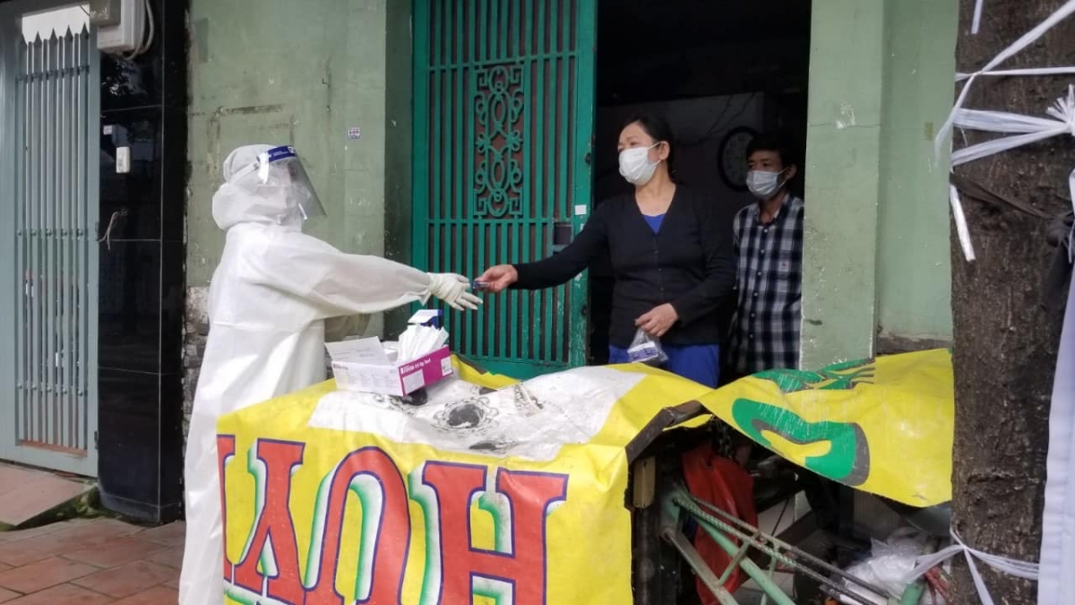 Người dân được nhân viên y tế hướng dẫn tự xét nghiệm.