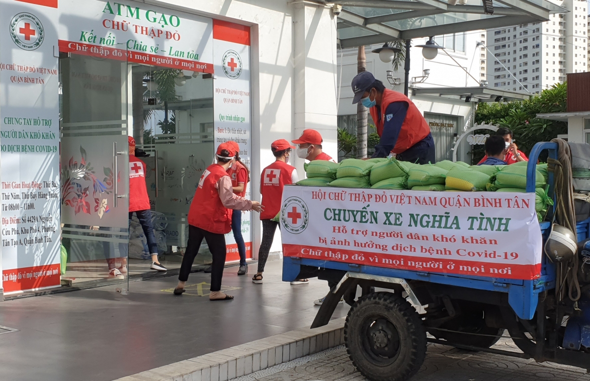 Cán bộ, hội viên và tình nguyện viên Chữ thập đỏ vận chuyển hàng đến điểm hỗ trợ người khó khăn do dịch covid-19