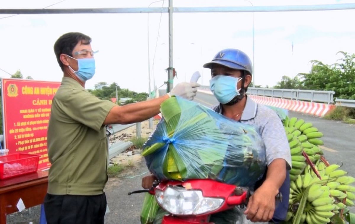 cựu chiến binh tham gia đo thân nhiệt người dân tại một chốt kiểm soát dịch