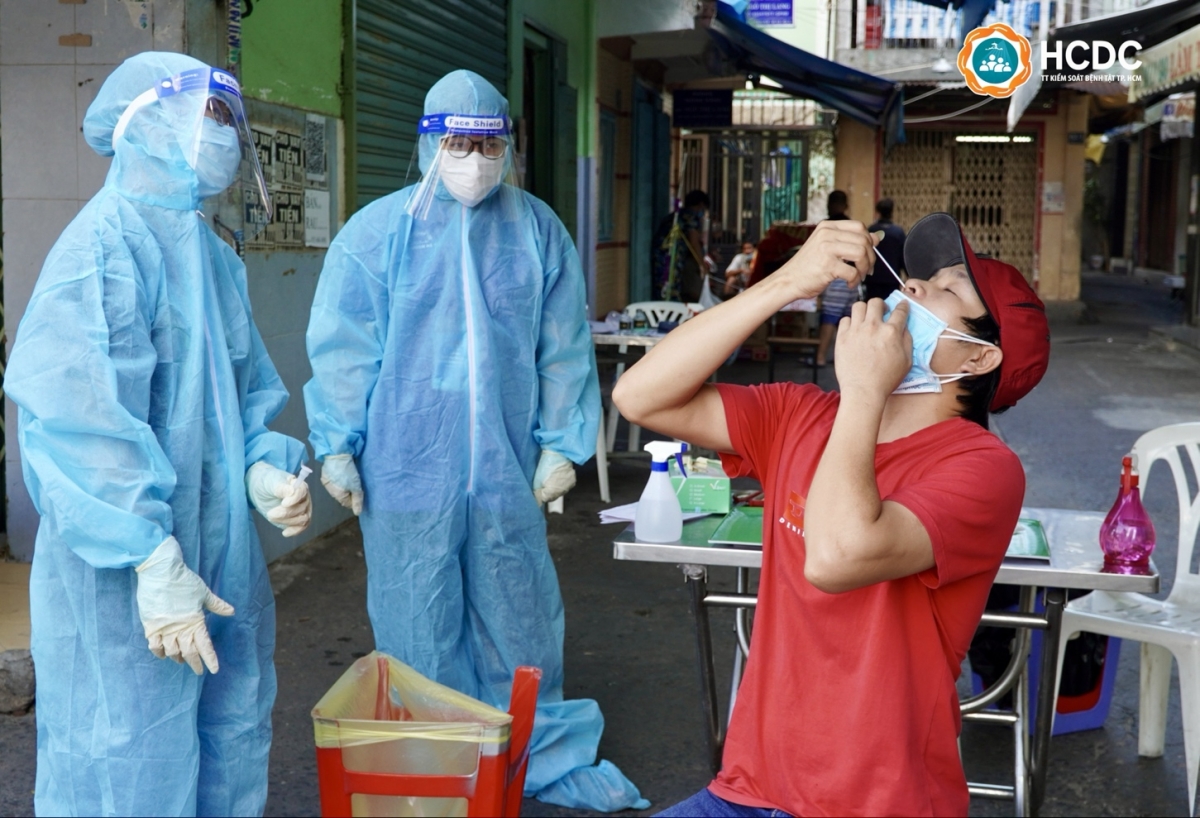 Nhân viên y tế hướng dẫn người dân tự test nhanh bằng kháng nguyên