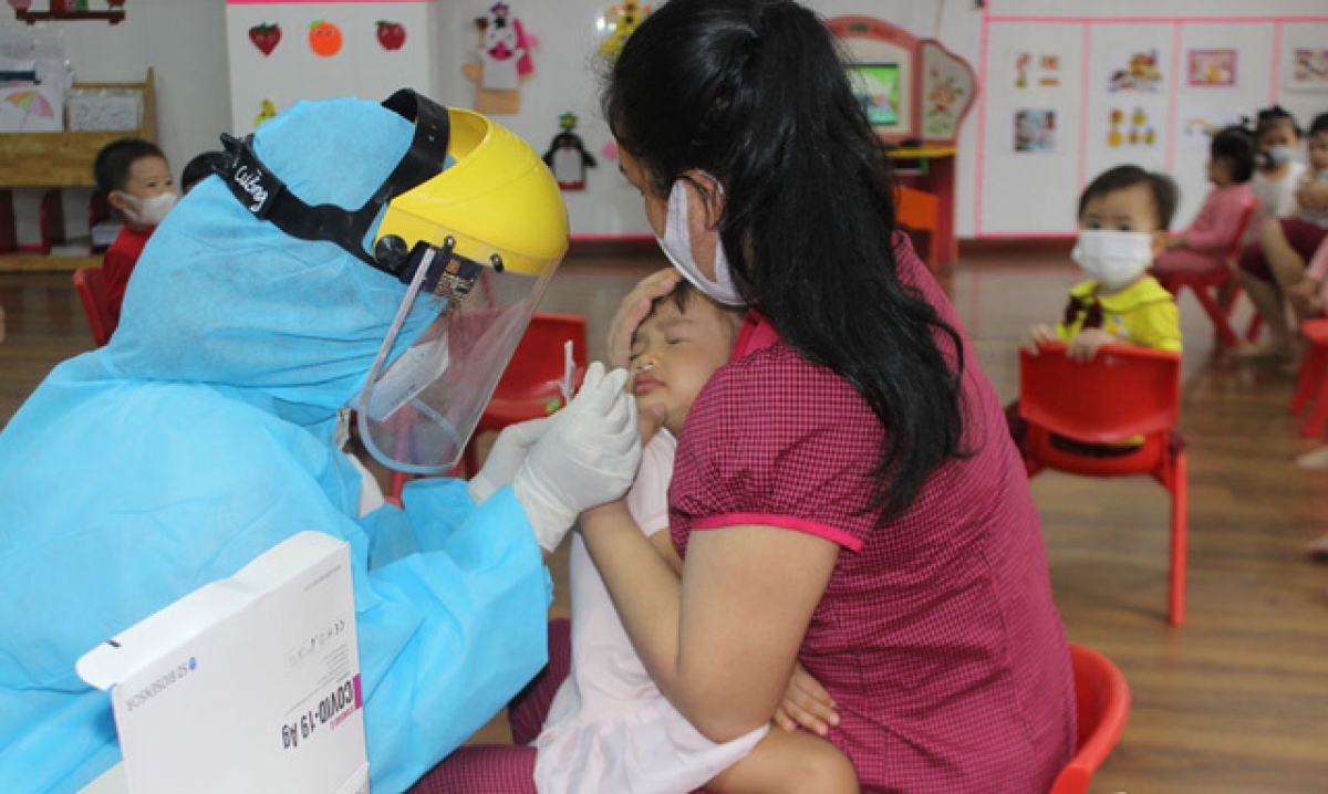 Nhân viên y tế lấy mẫu xét nghiệm cho học sinh trường Mầm non Sao Mai, TP Bắc Ninh.