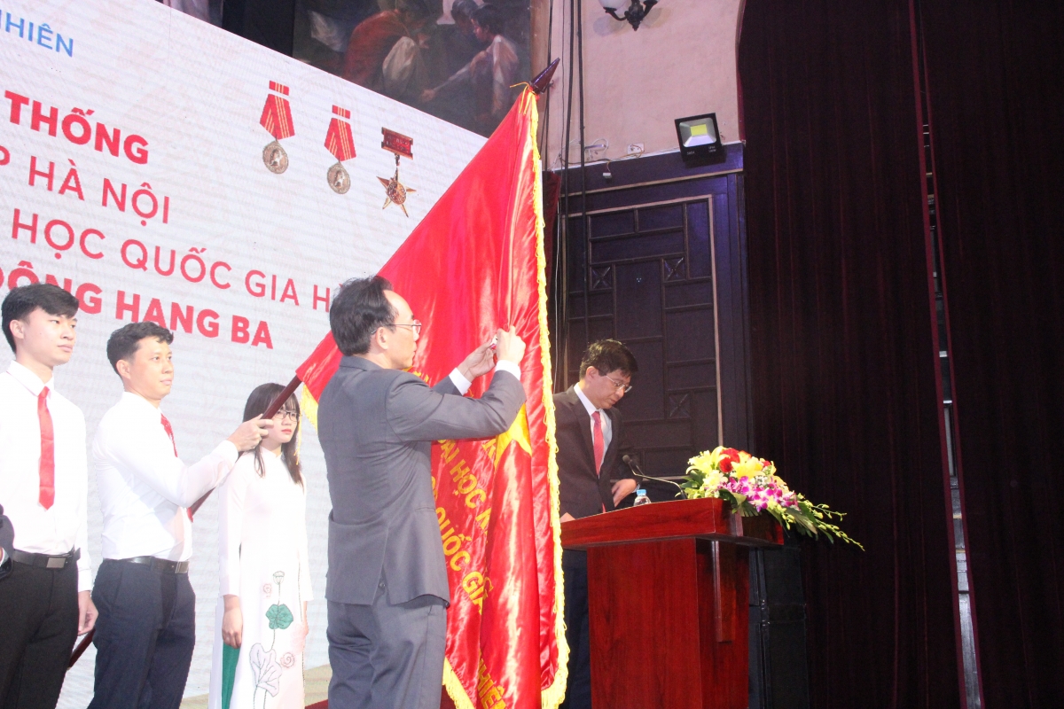 Thứ trưởng Hoàng Minh Sơn gắn huân chương Lao động hạng Ba lên lá cờ truyền thống của Trường ĐH Khoa học Tự nhiên ĐH Quốc gia Hà Nội