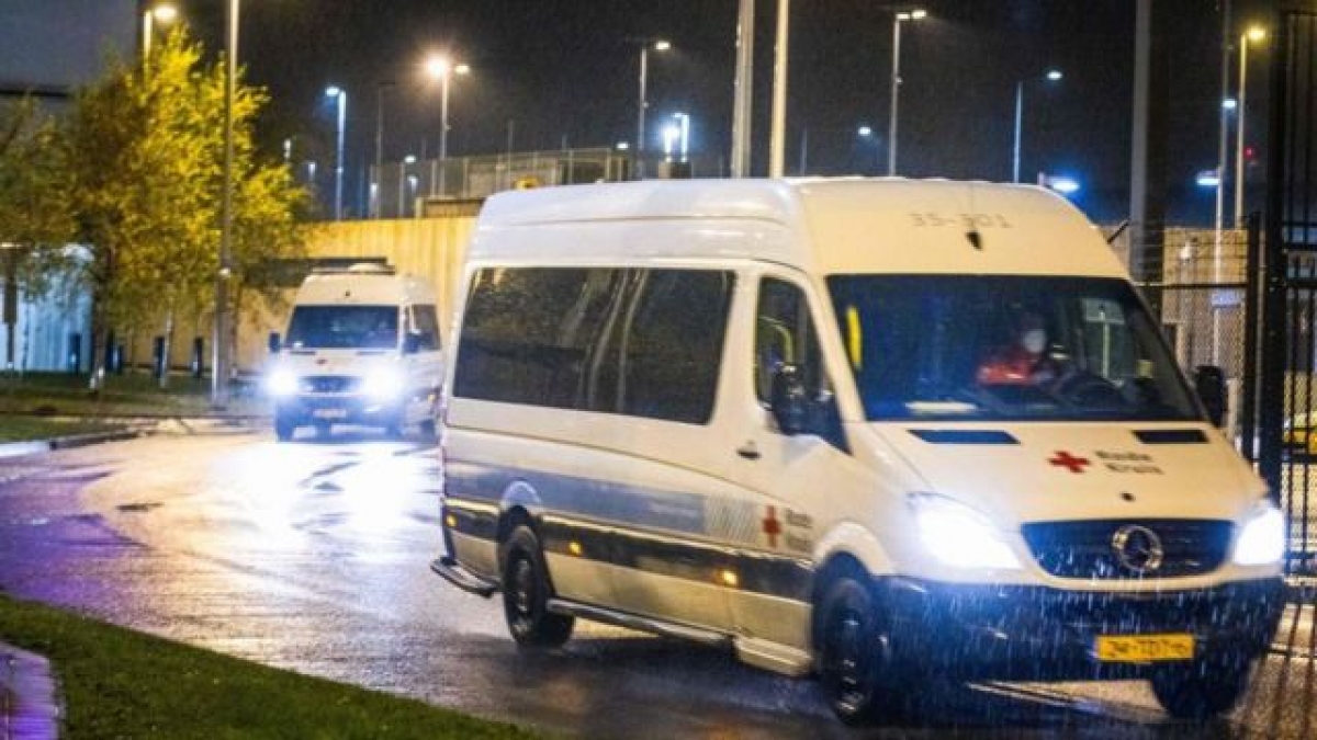 Chuyển các hành khách có xét nghiệm dương tính với Covid-19 trên chuyến bay từ Nam Phi đến sân bay Schiphol ở Amsterdam (Hà Lan) tới khu cách ly. Ảnh AFP/TTXVN