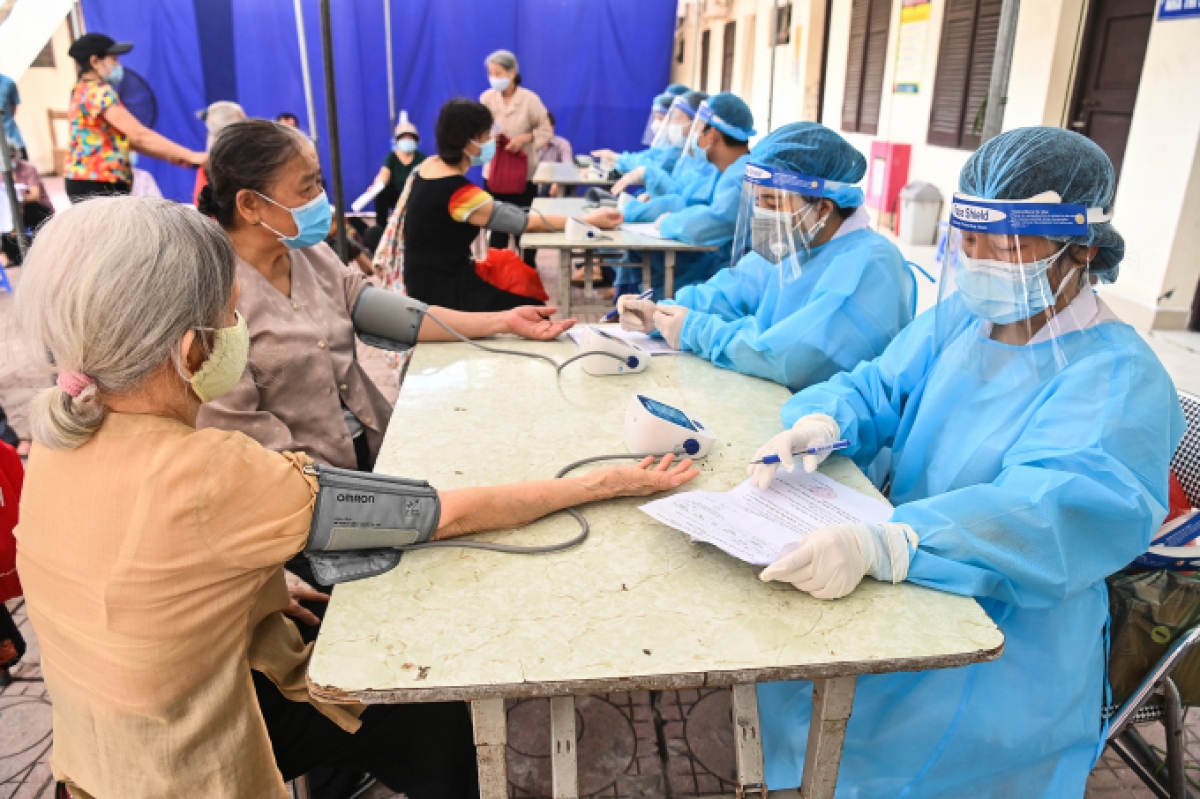Người dân kiêm tra sức khỏe trước khi tiêm vaccine Covid-19