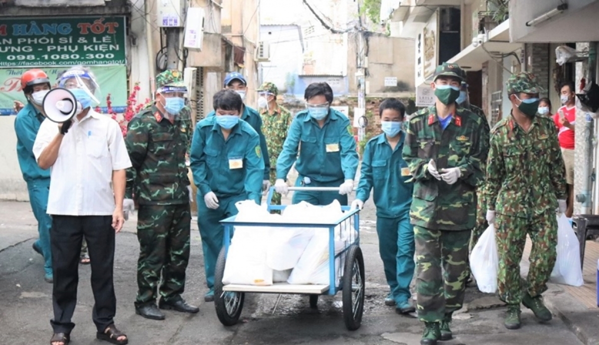 Trưởng khu phố 7 Lê Ngữ (áo trắng) với chiếc loa gọi từng người ra nhận gói an sinh đã trở thành hình ảnh không thể quên trong lòng người dân trong khu phố
