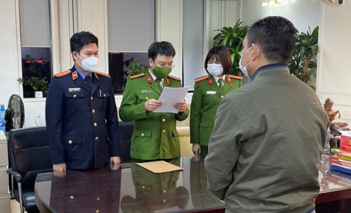 Cơ quan điều tra tống đạt quyết định khởi tố, lệnh bắt tạm giam giám đốc CDC Hải Dương. Ảnh KT