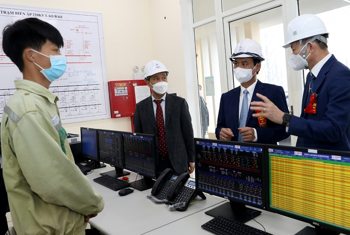 Ông Nguyễn Tuấn Tùng hướng dẫn các đại biểu là ông Võ Văn Hưng - Chủ tịch UBND tỉnh Quảng Trị, ông Trần Đình Nhân - TGĐ Tập đoàn Điện lực Việt Nam (EVN) thăm trạm biến áp 220kV Lao Bảo (Ảnh: Ngọc Hà)