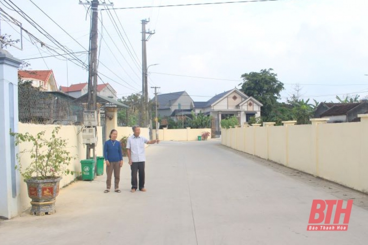 Vợ chồng ông Thiều Thọ Tam và con đường được làm trên đất cũ của gia đình.
