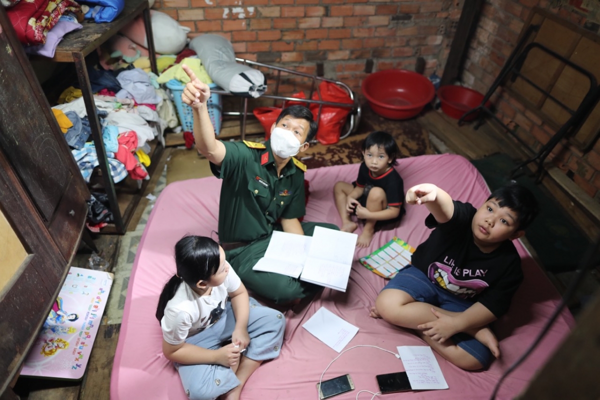 Thiếu tá Kiên kiểm tra bài vở của Đình Huy và Bảo Ngọc.