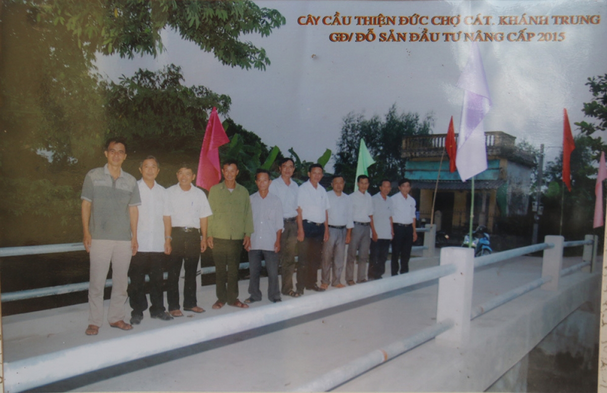 Bức ảnh ông Sản chụp cùng đại diện chính quyền địa phương ngày khánh thành cầu chợ Cát.