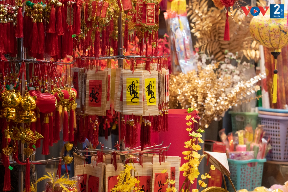 Câu đối, pháo hoa, lời chúc... được nhiều gia đình tìm mua để trang trí cành đào, cây quất. Giá bán dao động từ 80.000 - 120.000 đồng/sản phẩm. Dây treo trang trí hình con hổ vàng có giá từ 30.000 - 200.000 đồng/sợi tùy kích thước và kiểu dáng; lì xì in hình hổ vàng 10.000 - 50.000 đồng/xấp; đèn lồng có giá từ 150.000 - 350.000 đồng/cặp.