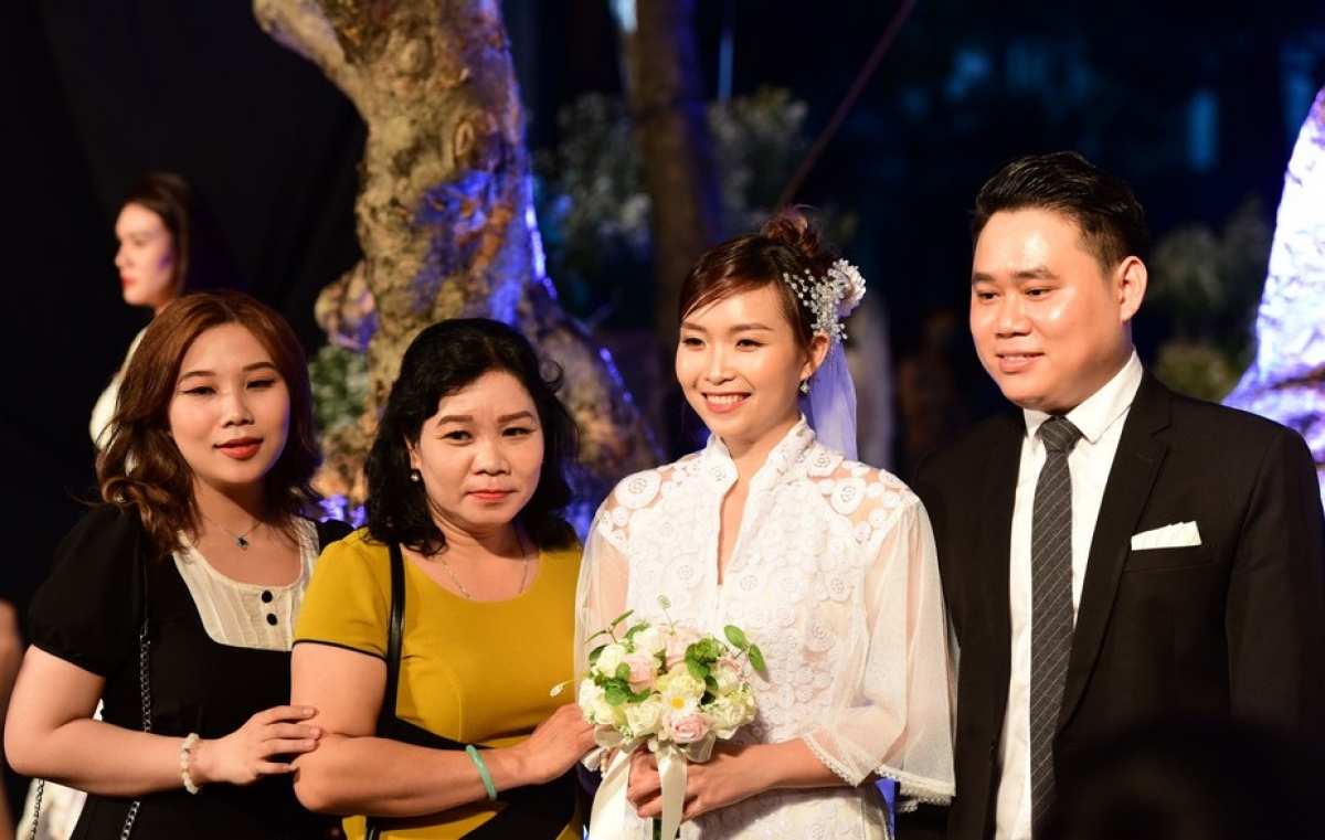 Bác sĩ khoa nhiễm khuẩn Nguyễn Trần Thị Vân An cùng chồng rạng rỡ chụp ảnh cùng người thân tại lễ cưới. Ảnh: Tuổi trẻ online