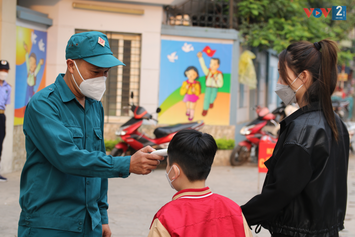 Lực lượng công an, dân phòng và đội Thanh niên Tình nguyện hỗ trợ công tác đón học sinh tại cổng trường.