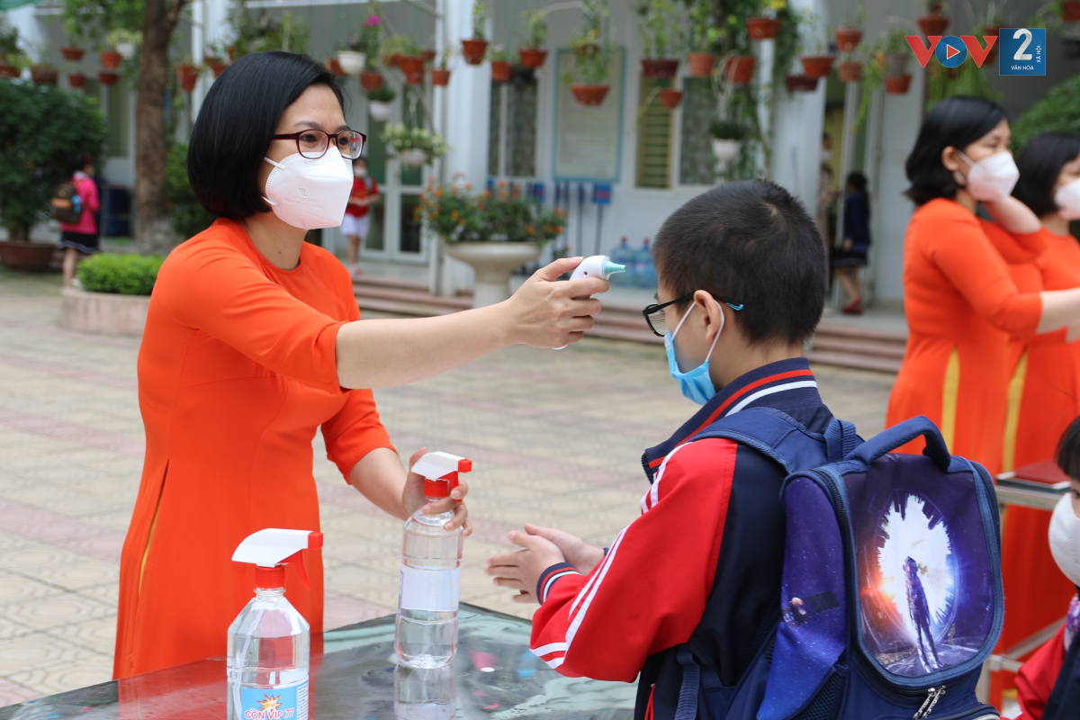 Giáo viên đo thân nhiệt cho từng học sinh ngay từ cổng trường.
