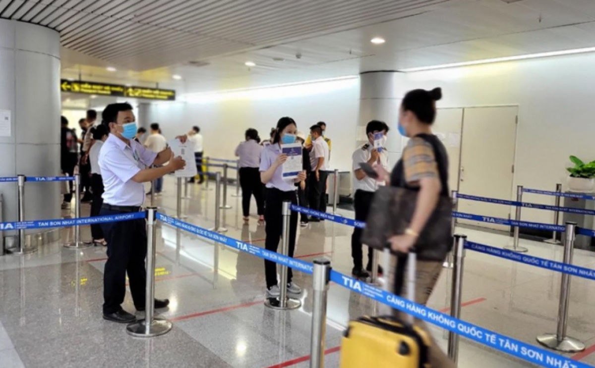 Nhân viên HCDC yêu cầu hành khách trình mã QR để phân luồng vào làm thủ tục nhập cảnh
Ảnh: Sở Y tế TP.HCM