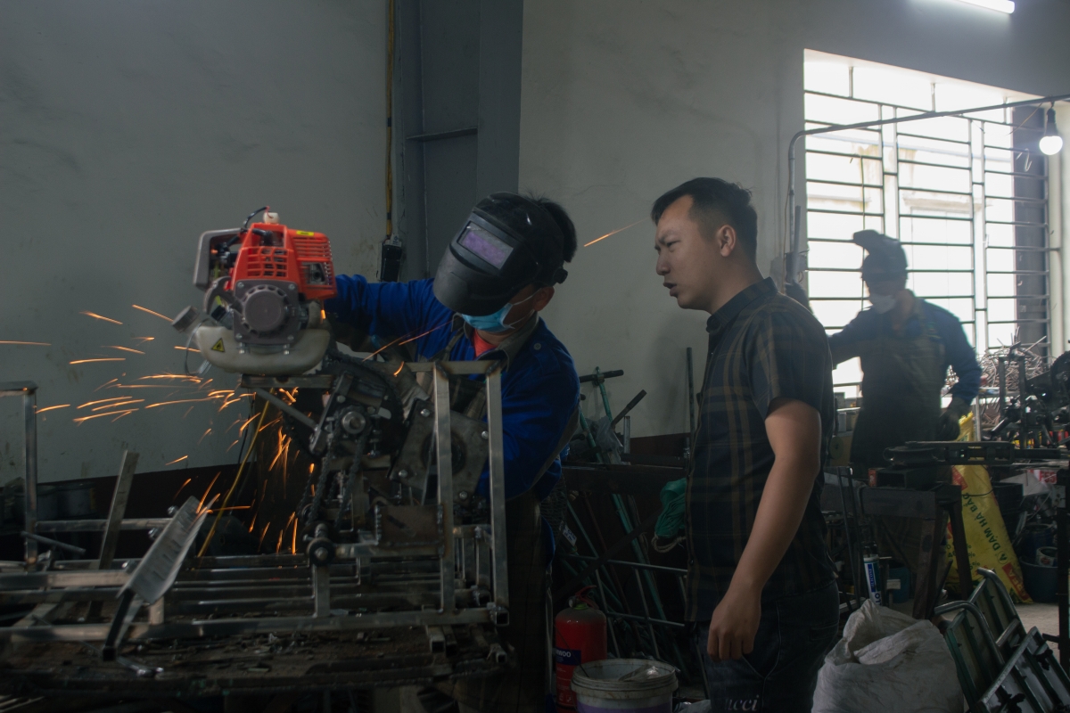 Anh con trai cả (áo kẻ) đã cùng bố Trần Đại Nghĩa nghiên cứu thử nghiệm thành công máy bay không người lái phun thuốc trừ sâu...