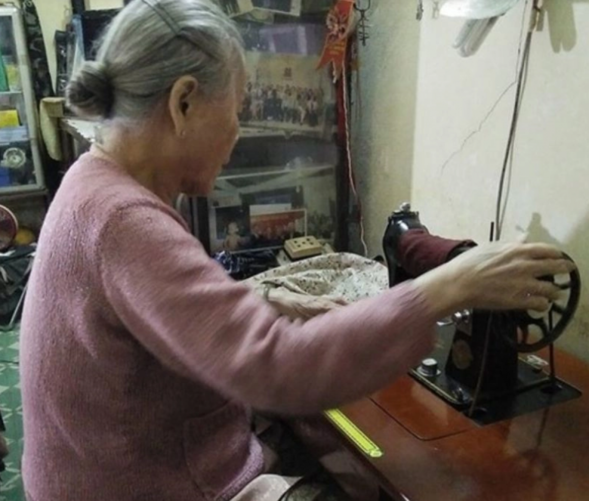 Bà Vy vẫn giữ thói quen may, đan quần áo dù tuổi đã cao. (Ảnh: Vietnamnet)