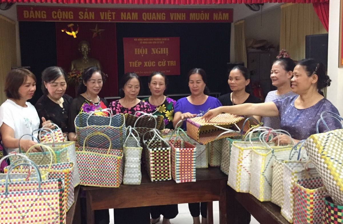 Những chiếc làn nhựa được bà Túc (người đứng ngoài cùng bên phải) và chị em phụ nữ phường Xuân La tạo ra từ những sợi dây buộc hàng bị thải bỏ