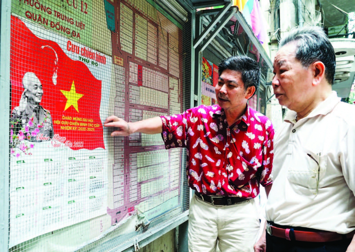 Ông Tích (bên phải ảnh) xung phong đảm nhận duy trì hoạt động
bảng tin của khu dân cư từ khi nghỉ hưu đến nay.