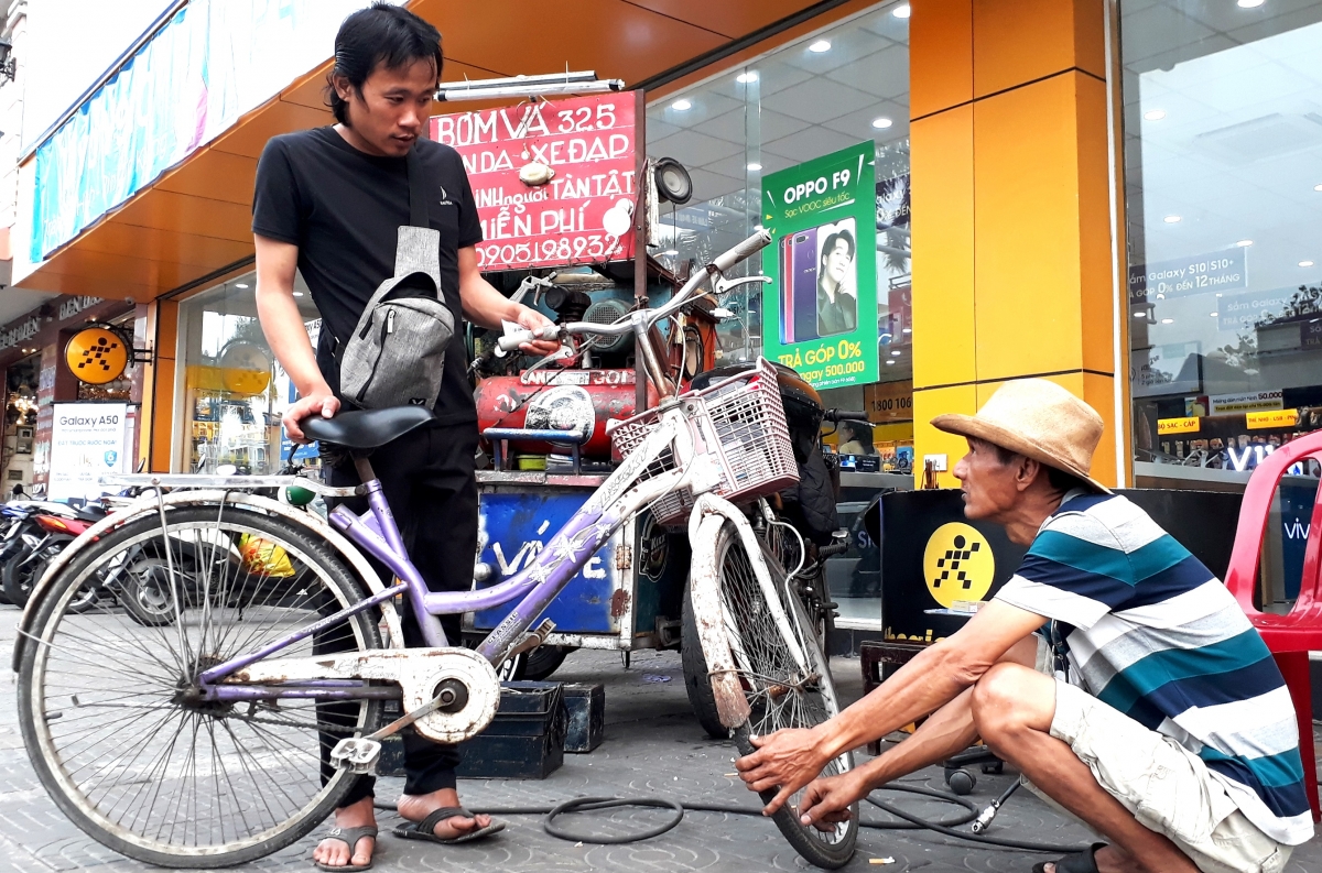 Ông Hùng bơm lốp miễn phí cho một người đi xe đạp