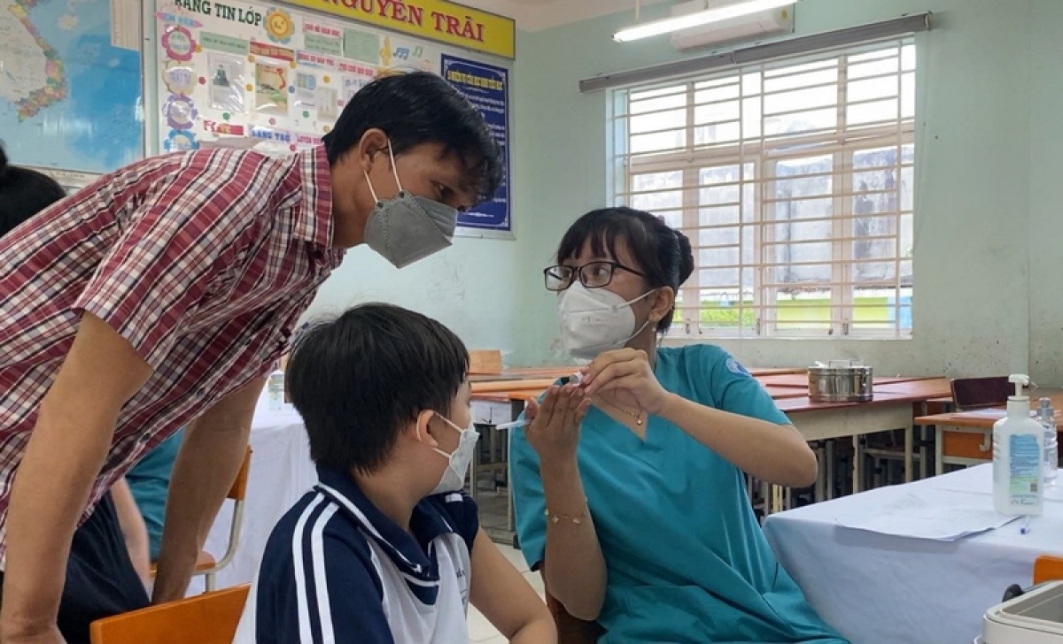 Tại điểm tiêm trường học, cha mẹ được nhân viên y tế hướng dẫn cụ thể về cách chăm sóc trẻ sau tiêm cũng như loại vaccine và hạn dùng