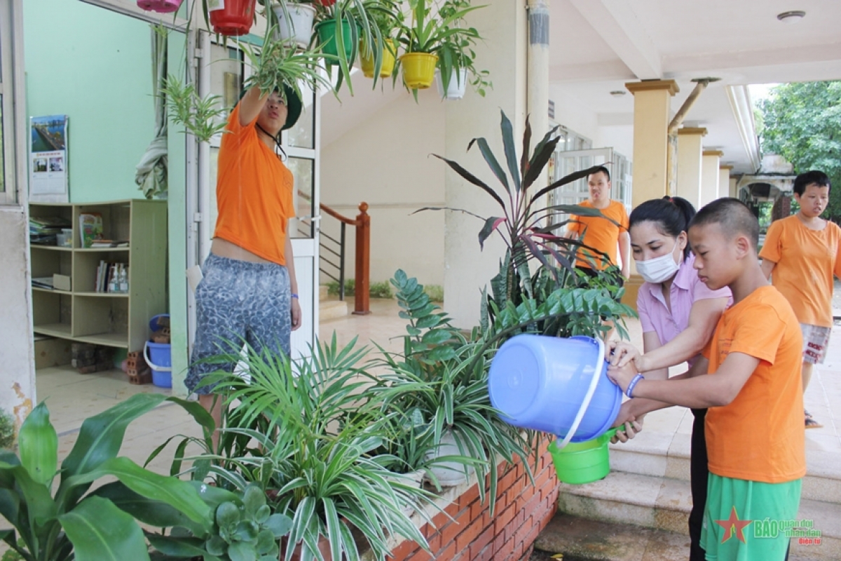 Mặc dù học sinh lớn gần bằng cô giáo, nhưng cô Bùi Thị Thu Hà, lớp Giáo dục đặc biệt 2 vẫn phải “cầm tay chỉ việc” hướng dẫn học sinh tưới cây.