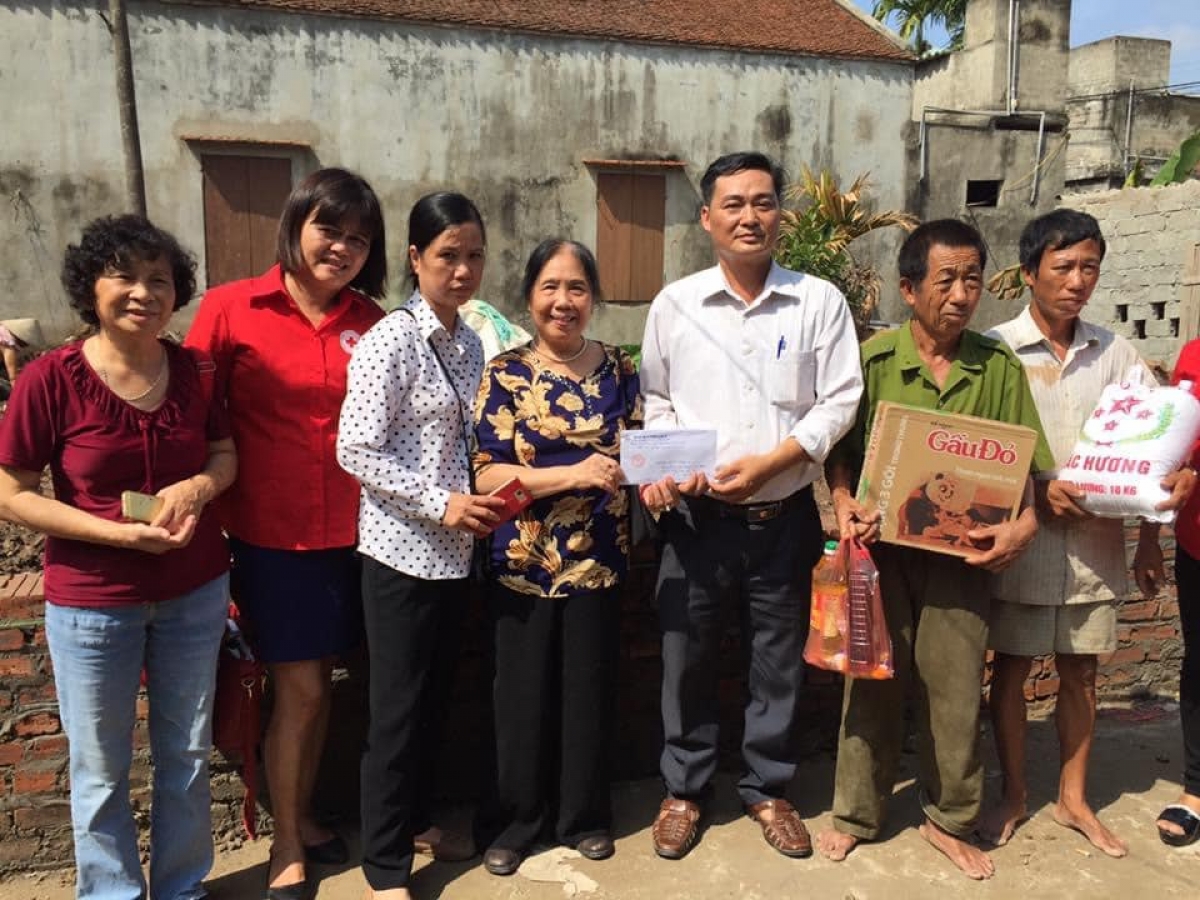 Bà Chi (áo hoa) tặng quà cho gia đình khó khăn