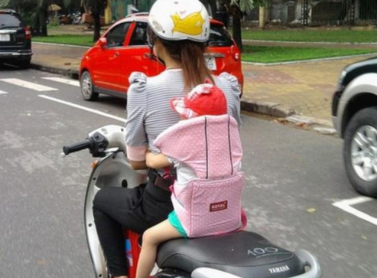 An toàn nhất là cho trẻ ngồi sau người lái và sử dụng đai an toàn