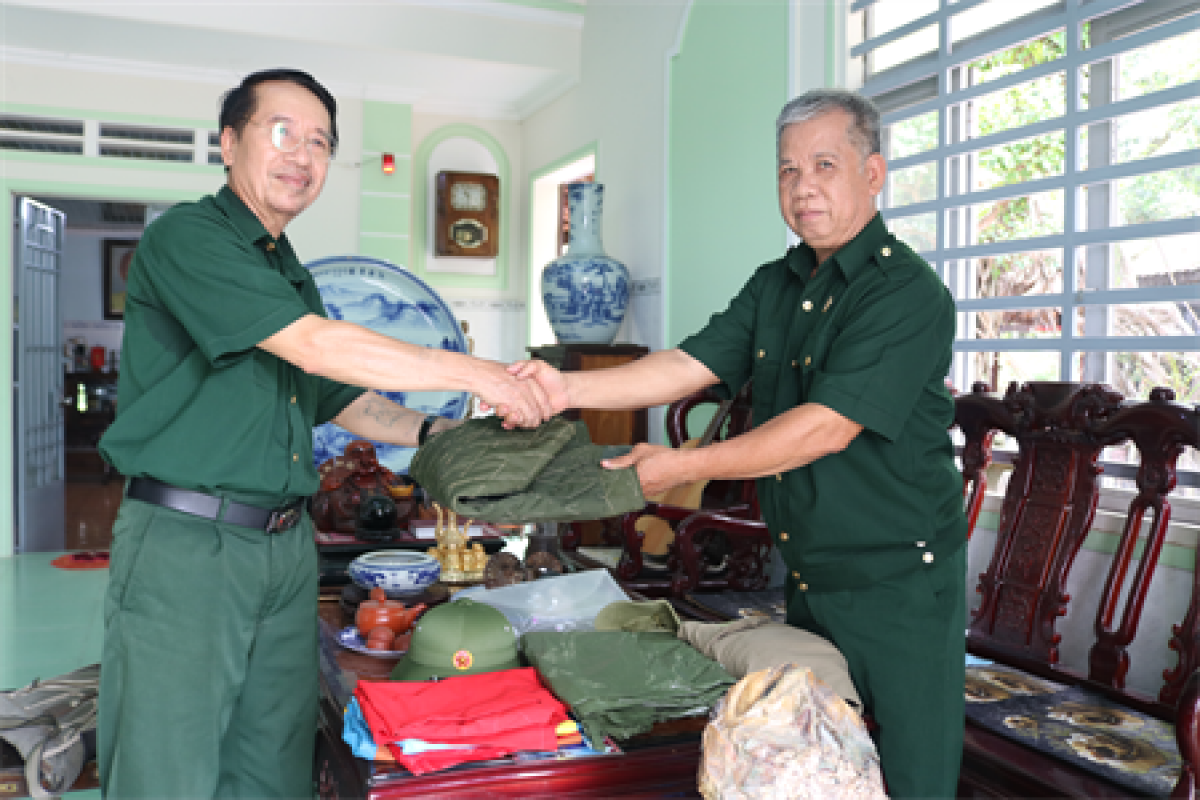 Cựu chiến binh Trần Ngọc (trái) nhận các kỷ vật của đồng đội gửi tặng