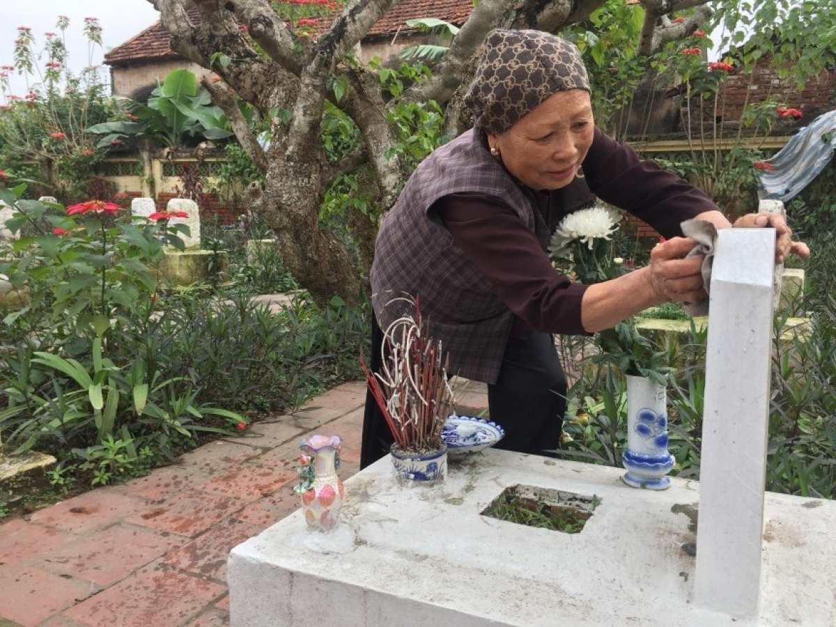 Bà Hồng đang lau chùi phần mộ liệt sỹ