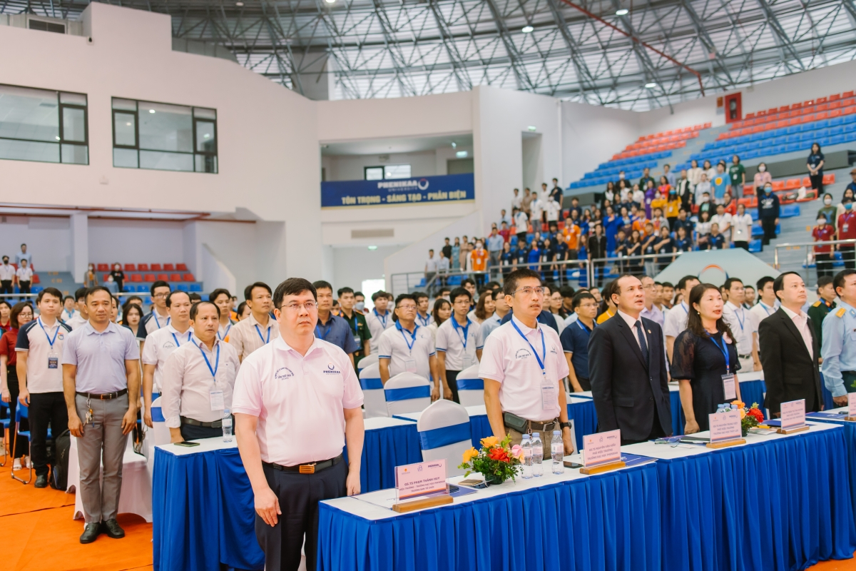 Các đại biểu và các sinh viên tham gia cuộc thi làm lễ chào cờ