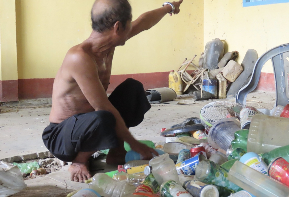 Ông Tuốt phân loại rác sau một chuyến đi vớt trên sông.