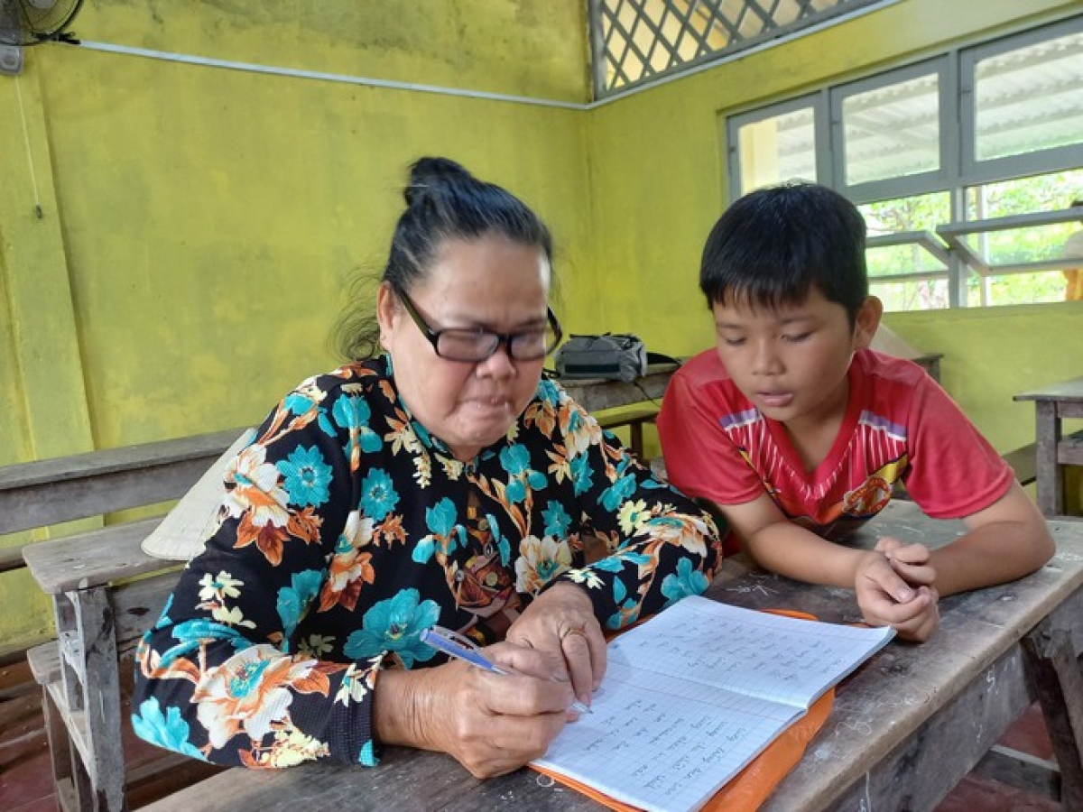 Một học viên được cháu ngoại hướng dẫn cách đánh vần