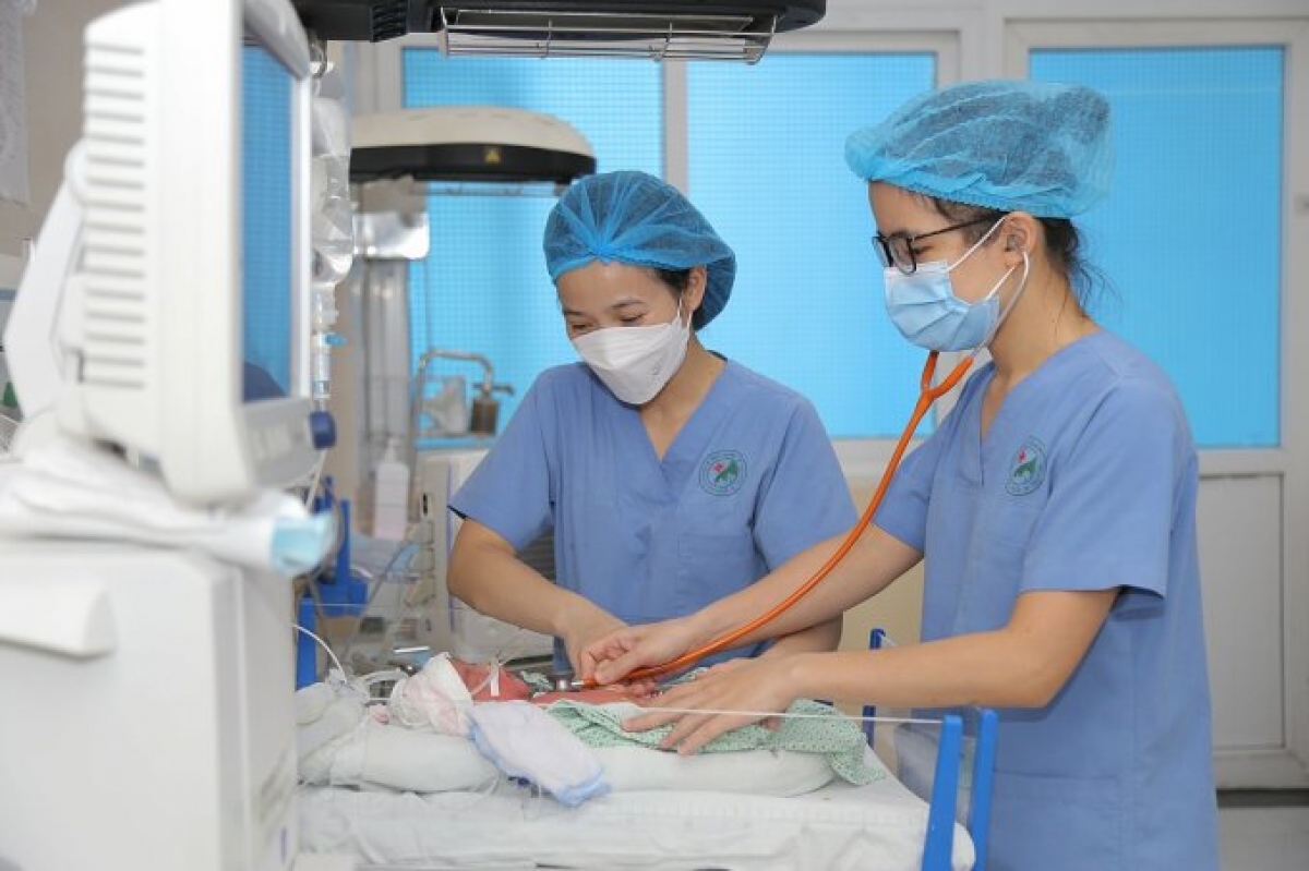 Các bác sĩ, điều dưỡng khoa Sơ sinh, BV Đức Giang đang chăm sóc bé sơ sinh bị sốt xuất huyết.