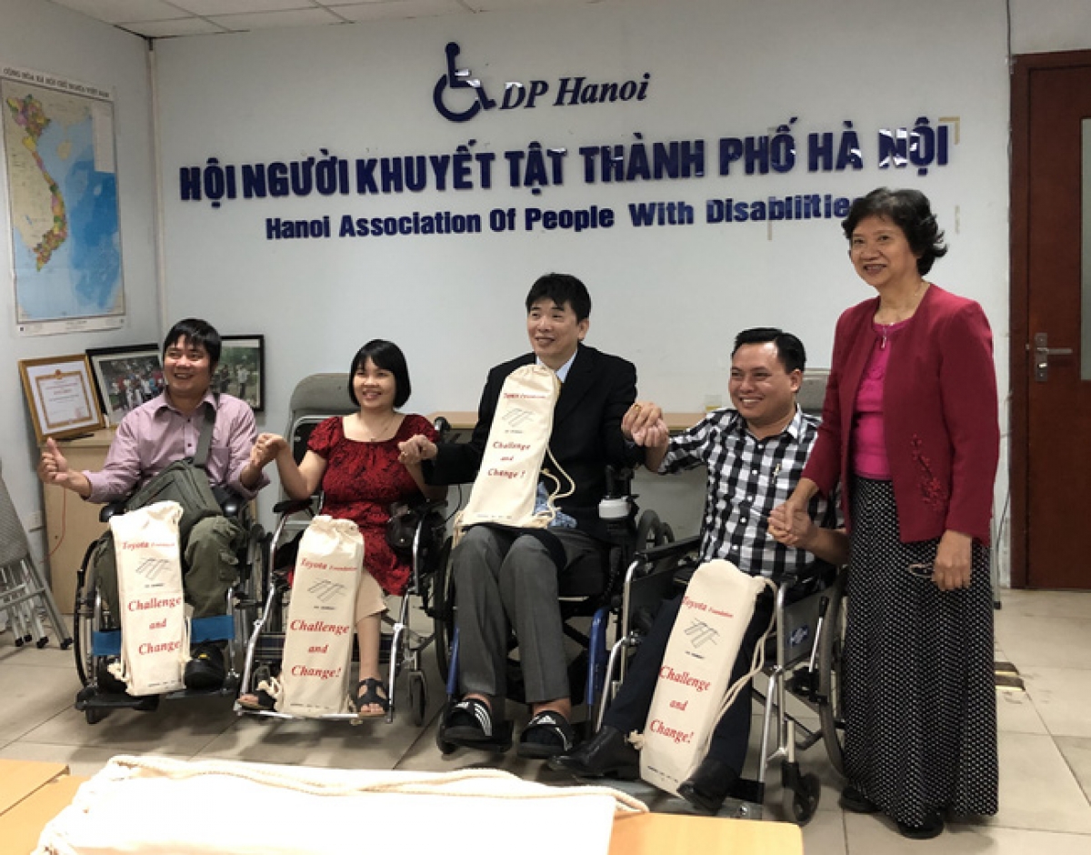 Bà Dương Thị Vân (đứng) - trao quà cho người khuyết tật Hà Nội