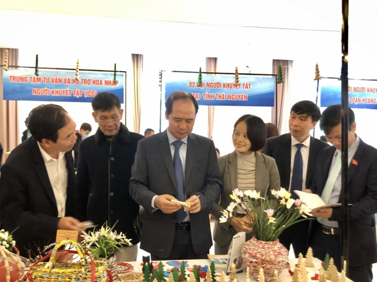 Thứ trưởng Bộ LĐ-TB&XH Nguyễn Văn Hồi (thứ ba từ bên trái sang) tham quan gian hàng giới thiệu nhiều sản phẩm do người khuyết tật làm