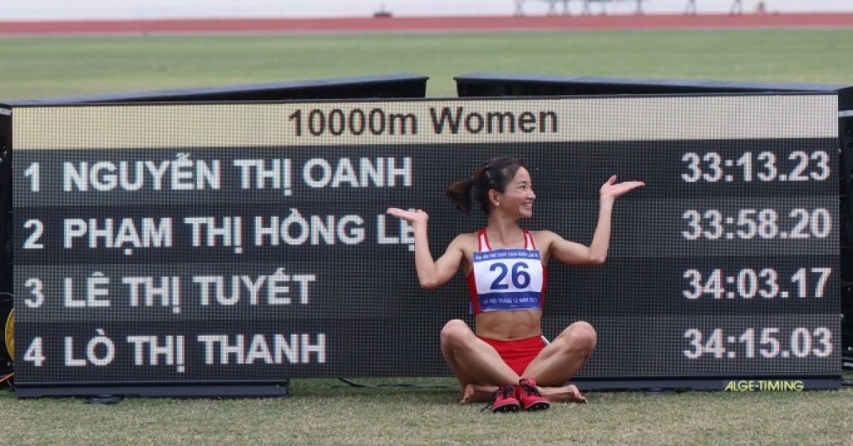 Nguyễn Thị Oanh bên bảng điện tử ghi thành tích của các VĐV dự thi 10.000m. Ảnh: Văn Lượng