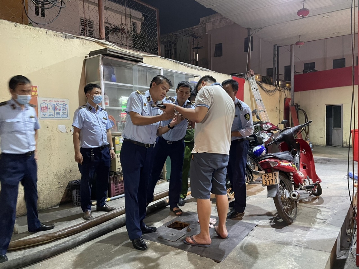 Ông Trần Việt Hùng (giữa) cùng lực lượng Quản lý thị trường TP HN kiểm tra một cửa hàng
kinh doanh xăng dầu trên địa bàn