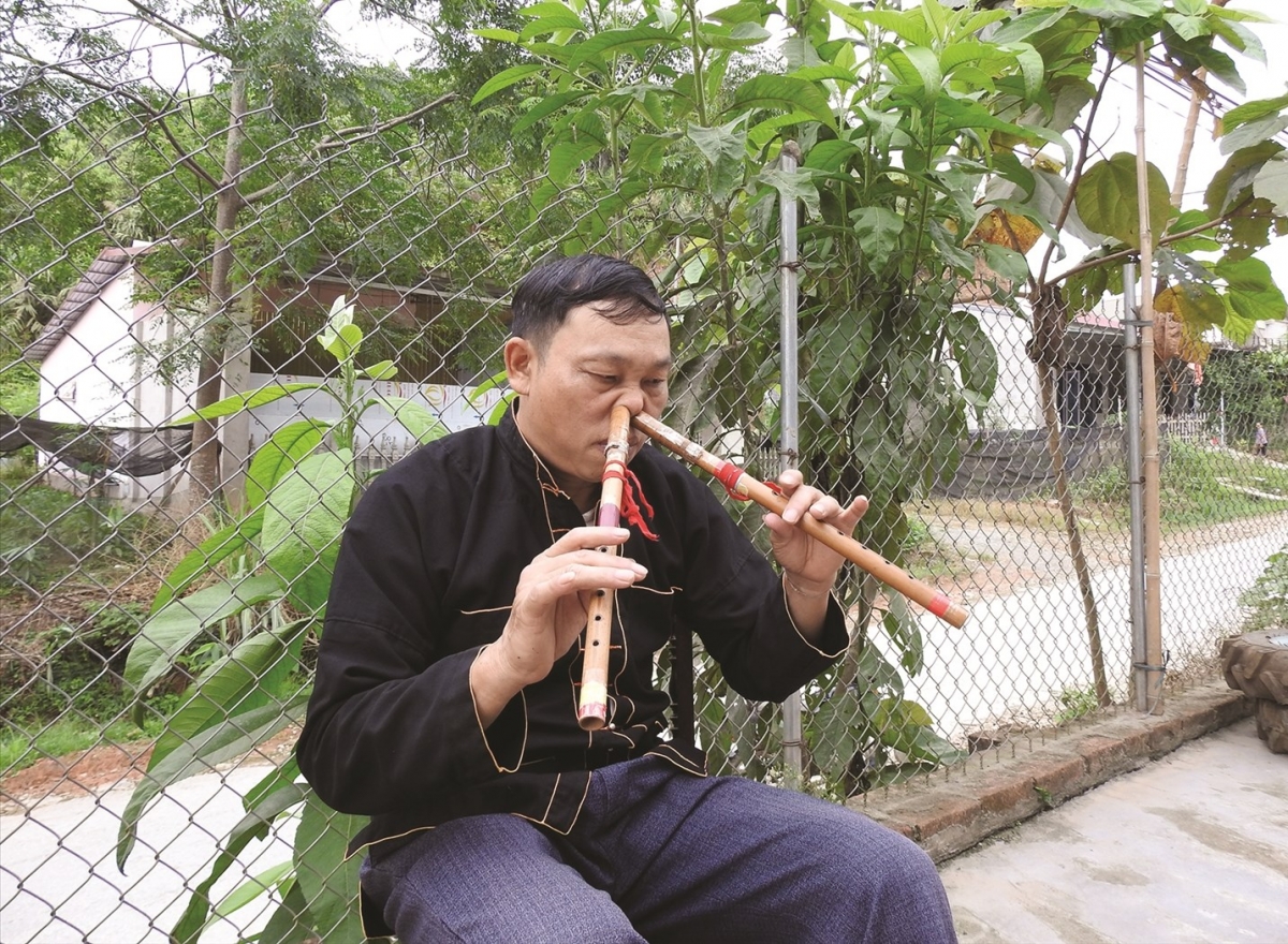 Không chỉ say mê Páo dung, NNƯT Đặng Nho Vượng còn thổi sáo bằng mũi một cách điêu luyện. Ảnh: baodantoc.vn