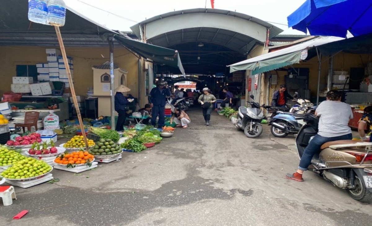 Chợ Phúc Đồng - Long Biên đã được xây dựng rất to, nhưng các tiểu thương vẫn quen xếp hàng bán ngay bên ngoài cổng, tràn ra con đường đi vào chợ.