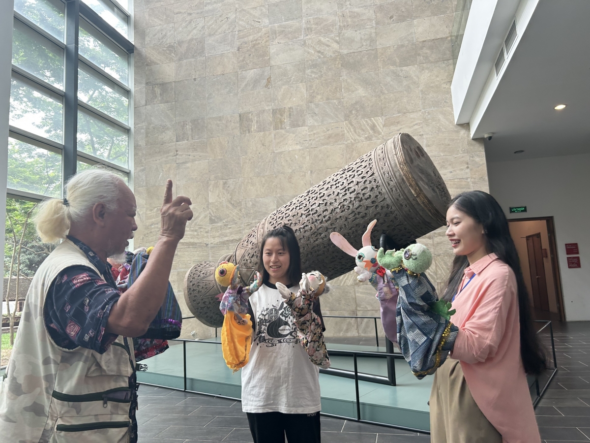 Khách tham quan học cách trình diễn rối độc thoại cùng nghệ sĩ Dương Văn Học.
Ảnh: Bảo tàng DTHVN