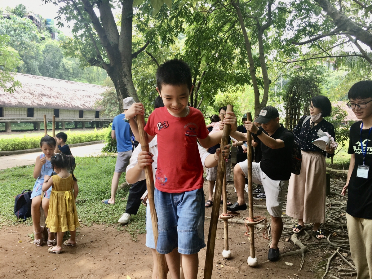 Các em nhỏ thử sức đi cà kheo. Ảnh: Bảo tàng DTHVN