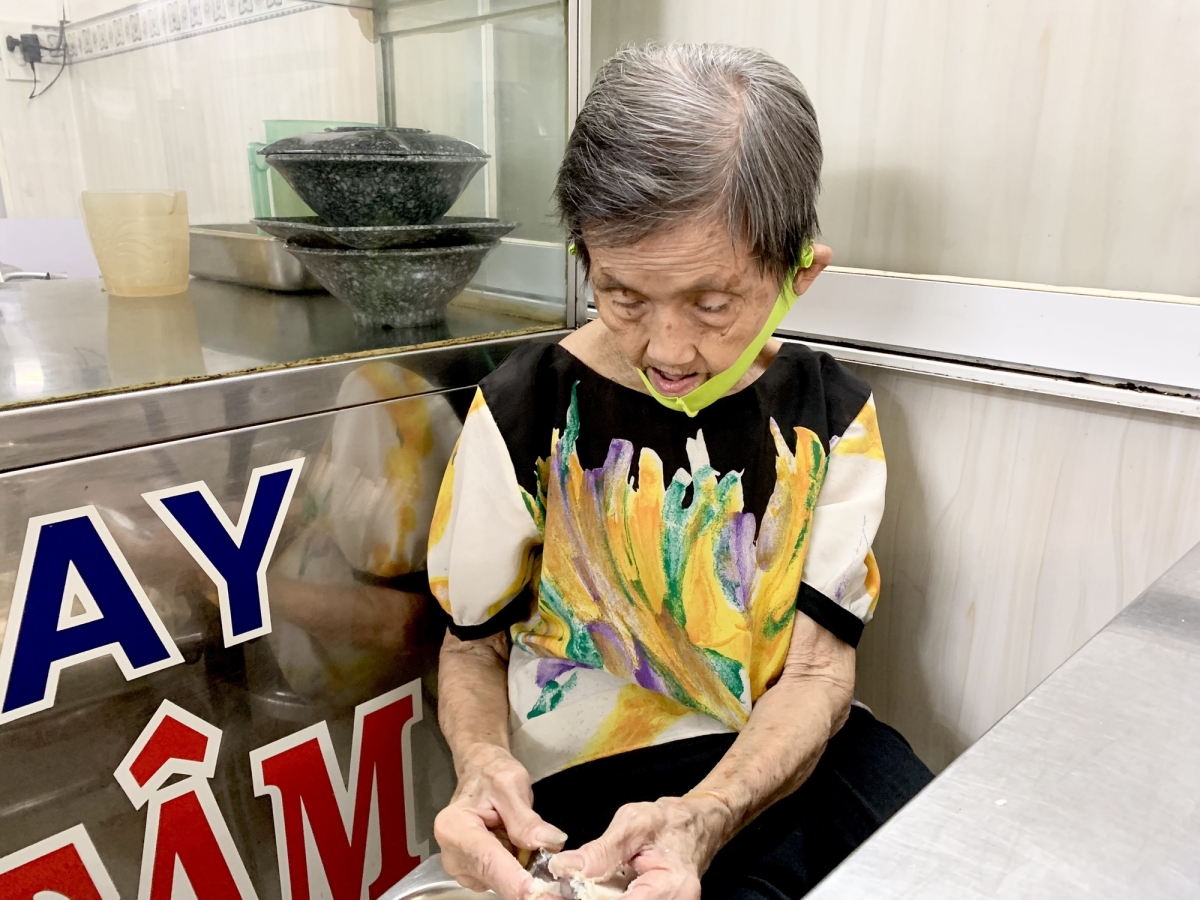 Bà Năm tỉ mỉ xé từng sợi mì.