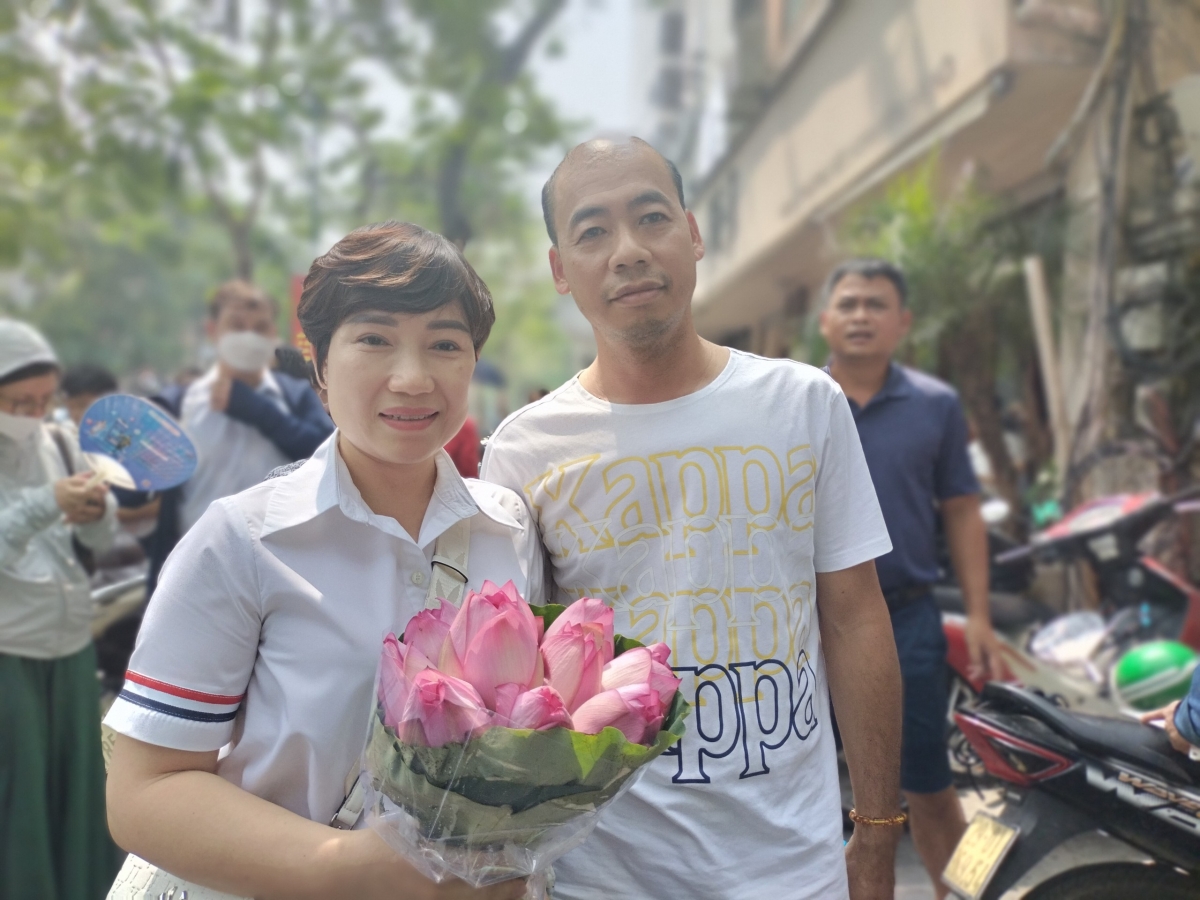 Phụ huynh chuẩn bị hoa tặng con hoàn thành bài thi môn Ngữ văn tại điểm thi trường THPT Việt Đức
