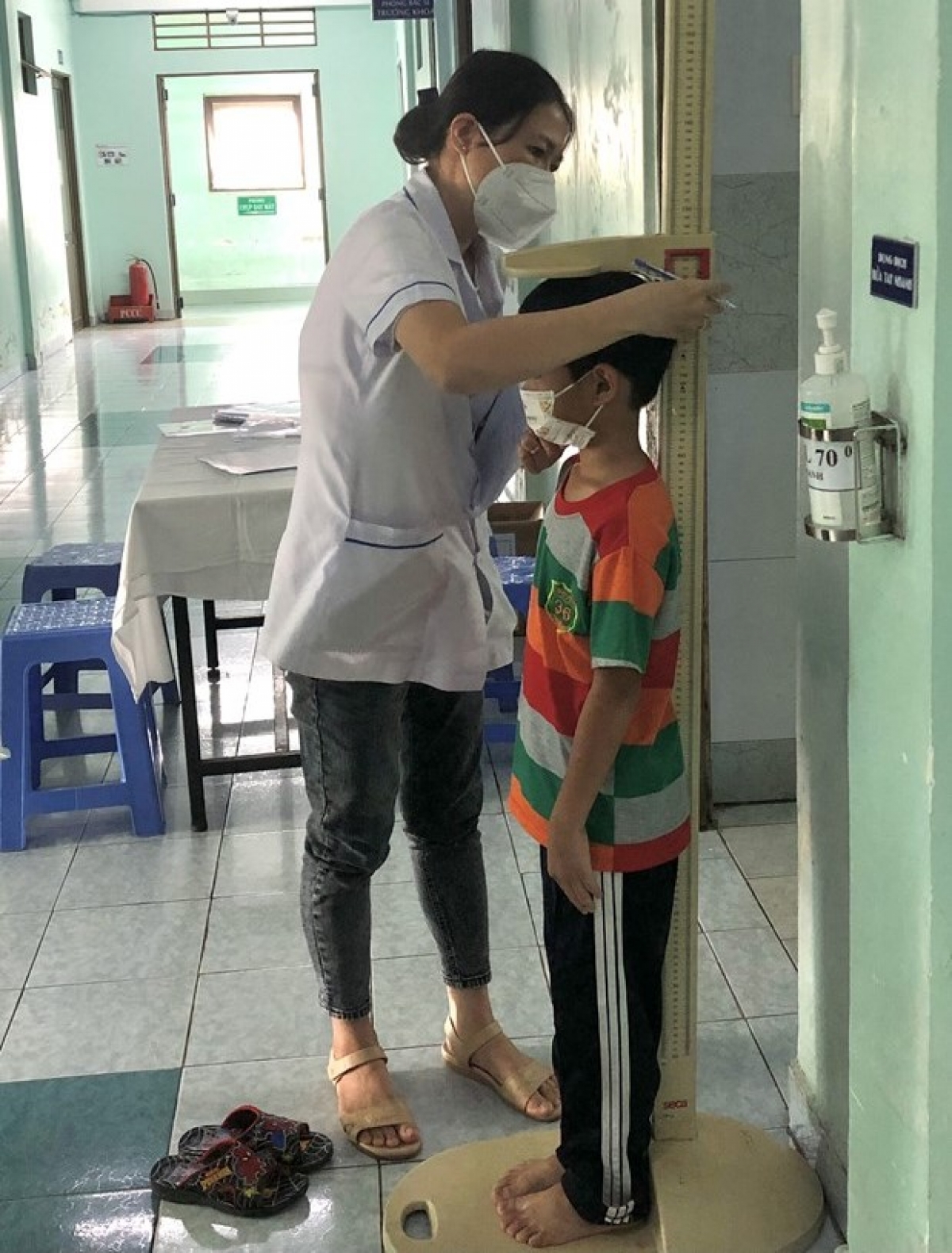 Nhân viên y tế đo chiều cao theo dõi tăng trưởng của trẻ.